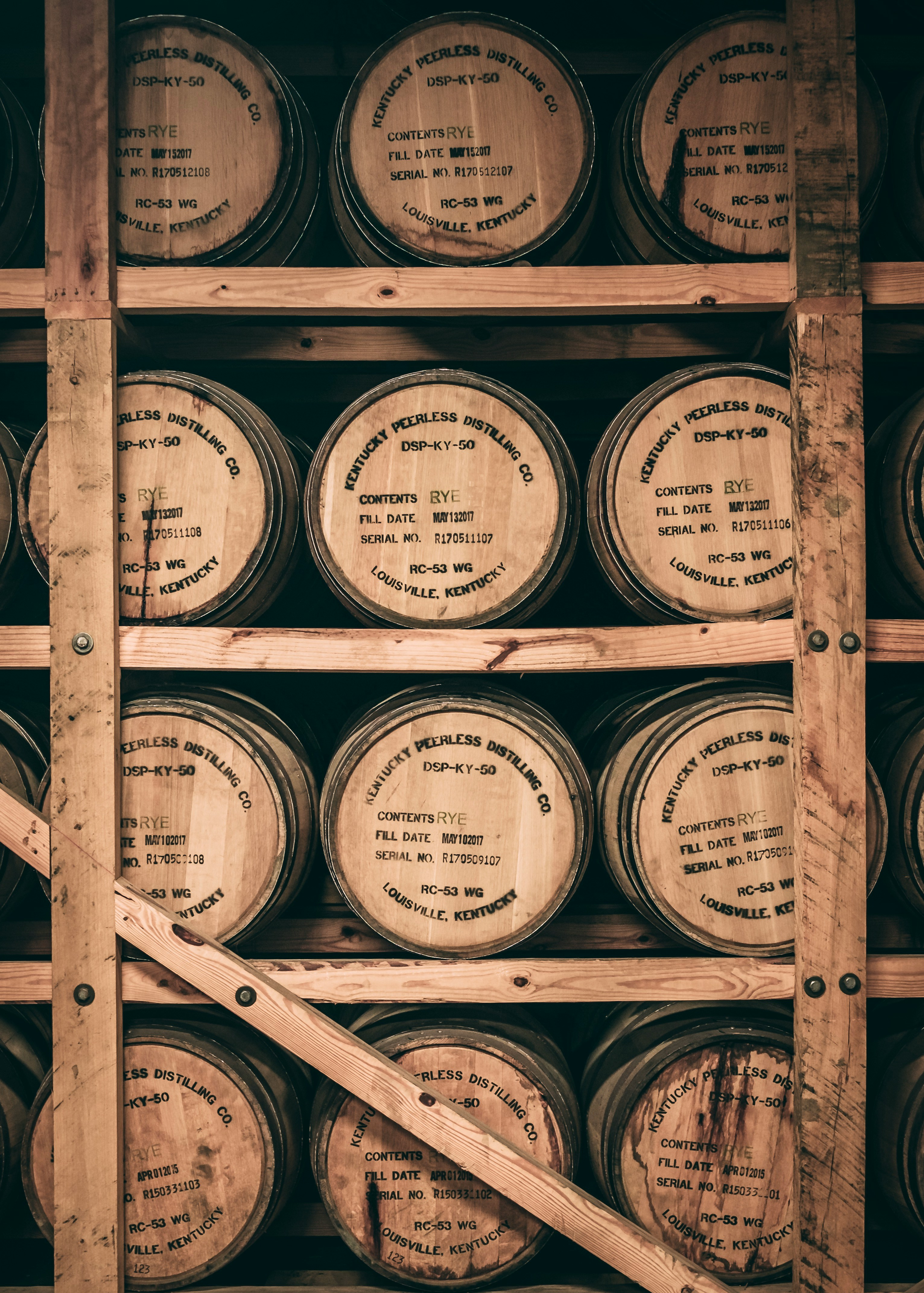 Rows of whiskey barrels aging inside a traditional rickhouse