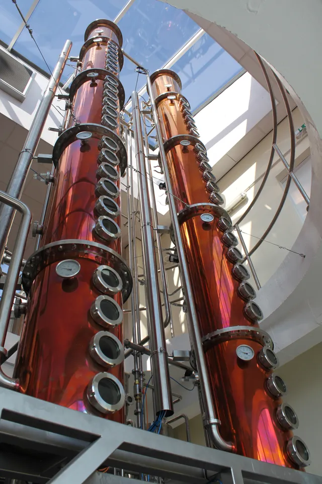 Tall copper and steel distillation columns at the Adnams Distillery in Southwold